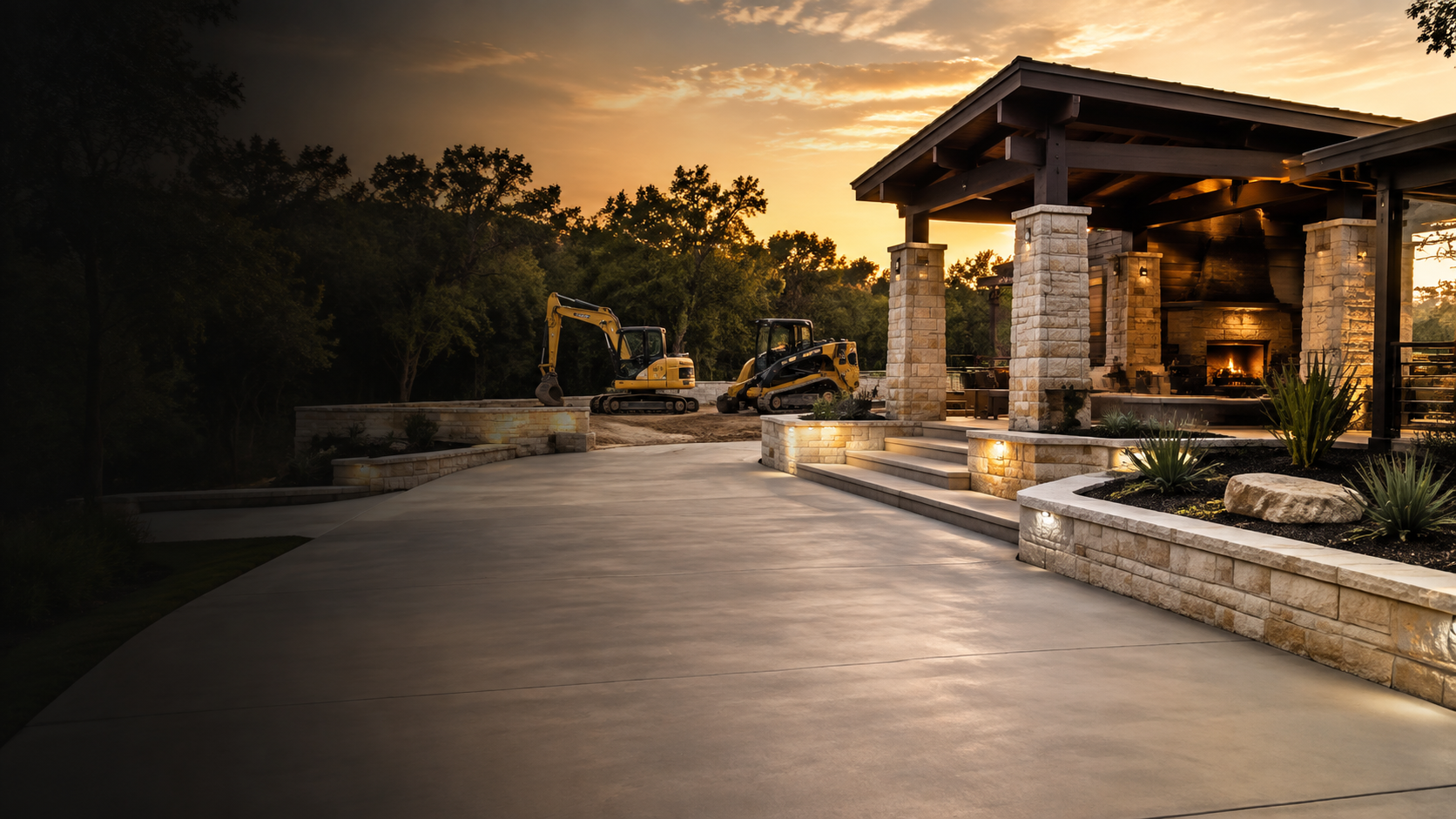 Finished concrete and limestone outdoor living project at golden hour with construction equipment